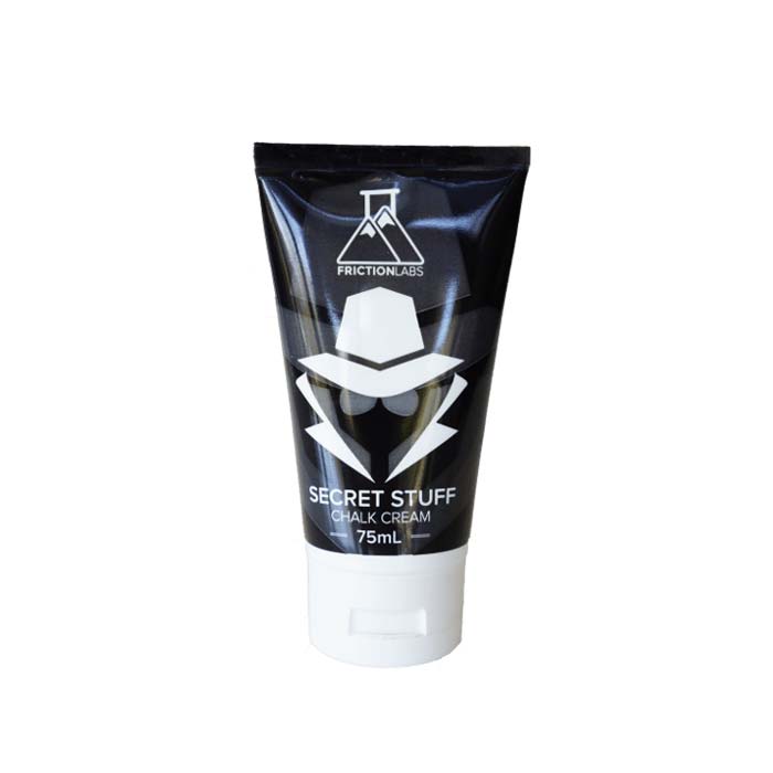 Das Bild zeigt eine schwarze Tube Liquid Chalk Secret Stuff von Frictionlabs. Sie steht am Kopf in Bildmitte. Man erkennt deutlich das Design des Produktes mit einem schematischen Dedektiv Kopf und Produktname.
