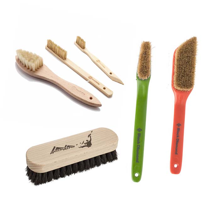 Das Bild zeigt eine Auswahl an unterschiedlichen Boulderbürsten die in jeder Boulderausrüstung zu finden sein sollten. Von links oben im Uhrzeigersinn sind zu sehen. Moon Holzbürsten, eine grüne und rote Black Diamond Boulderbürste und eine Austrialpin Sloper Brush.