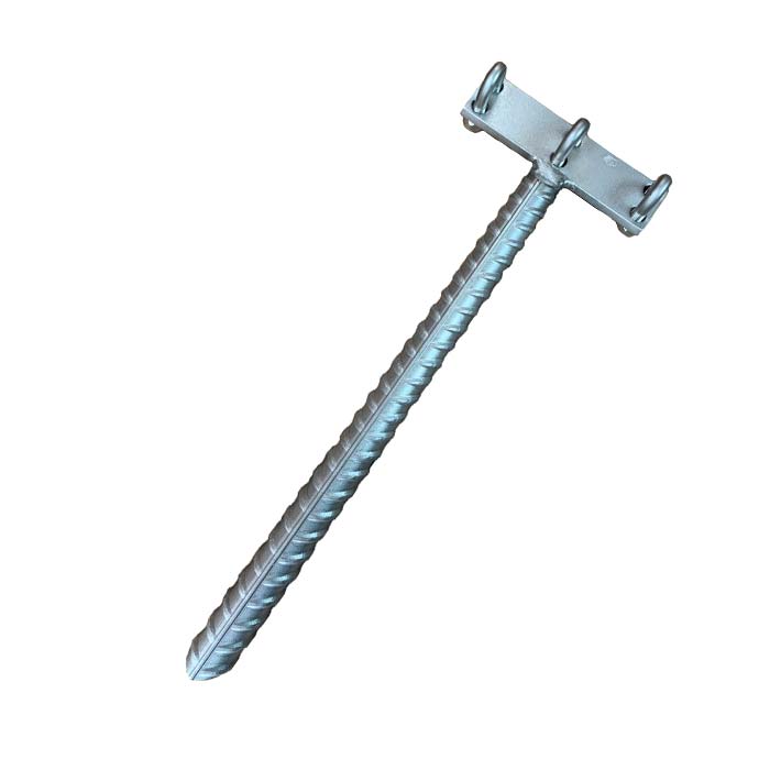 Das Bild zeigt einen silbernen Klettersteig Endanker verzinkt. Der T-förmige Anker liegt schräg in Bildmitte. Man erkennt den Bewehrungsstahl sowie die drei Klemmen am Kopf für das Stahlseil.