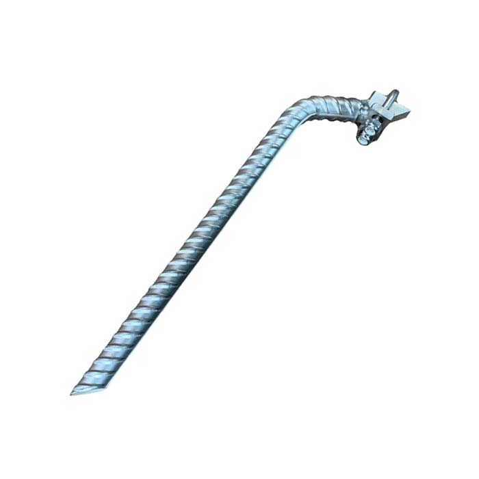 Das Bild zeigt einen silbernen Klettersteiganker vertikal verzinkt. Der Anker steht schräg in Bildmitte. Man erkennt den Bewehrungsstahl sowie den abgeschrägten Kopf mit der Klemme für das Stahlseil.