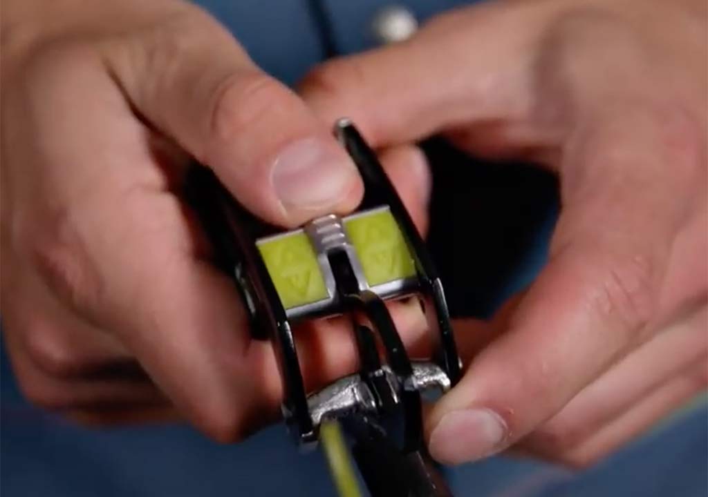 Das Bild zeigt den Schieber des Edelrid giga Jul Sicherungsgerätes. Zu sehen ist die Oberseite des Gerätes sowie ein Daumen der dabei ist den Schieber zu betätigen.