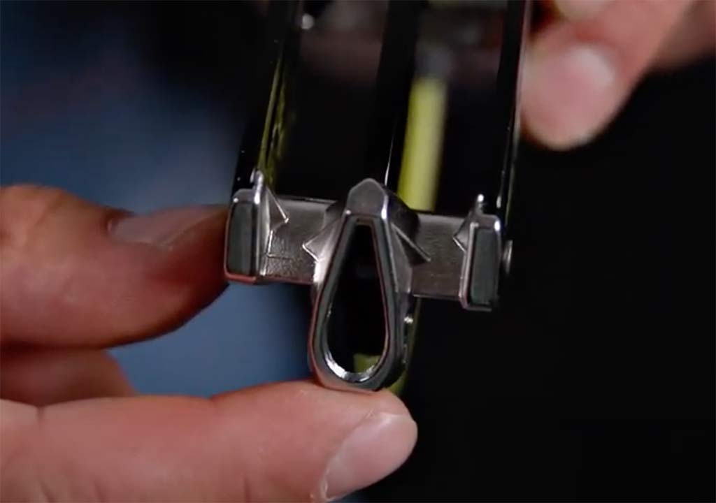 Das Bild zeigt das Edelrid Giga Jul Sicherungsgerät in einer Hand. Man erkennt die Rillen des Seilauslasses aus Edelstahl.