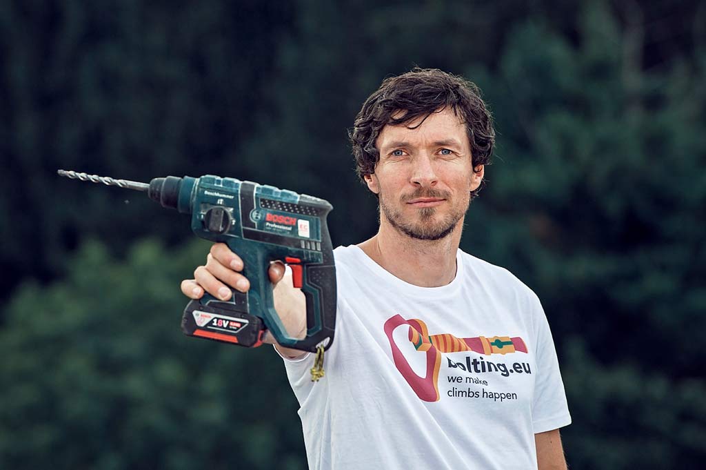 Das Bild zeigt den Betreiber des Einbohr Blog von bolting.eu und Geschäftsführer des Einbohrartikel Shops Gerhard Schaar. Er ist in einem weißem Shirt in Bildmitte zu sehen und hält eine Bohrmaschine in die Kamera.