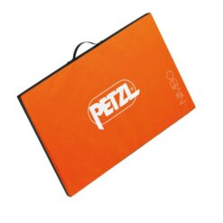 Das Bild zeigt das Petzl Nimbo Sitzstart Pad. Man sieht die orange Oberseite mit weißem Petzl Schriftzug und dem Produktnamen im rechten Eck der Matte. Oberhalb die schwarze Trageschlaufe.