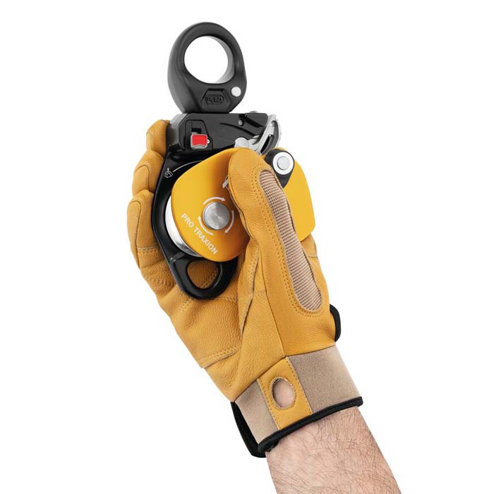 Halb geöffnete Seilrolle mit Rücklaufsperre in der Hand eines Anwenders mi Handschuh.