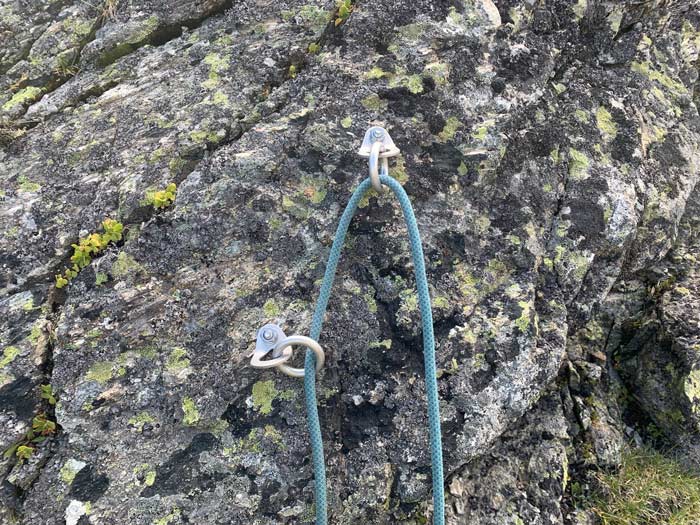 Das Bild zeigt eine korrekt eingerichtete Abseilstelle mit zwei einzelnen Bohrhakenlaschen mit Ring im Granit.