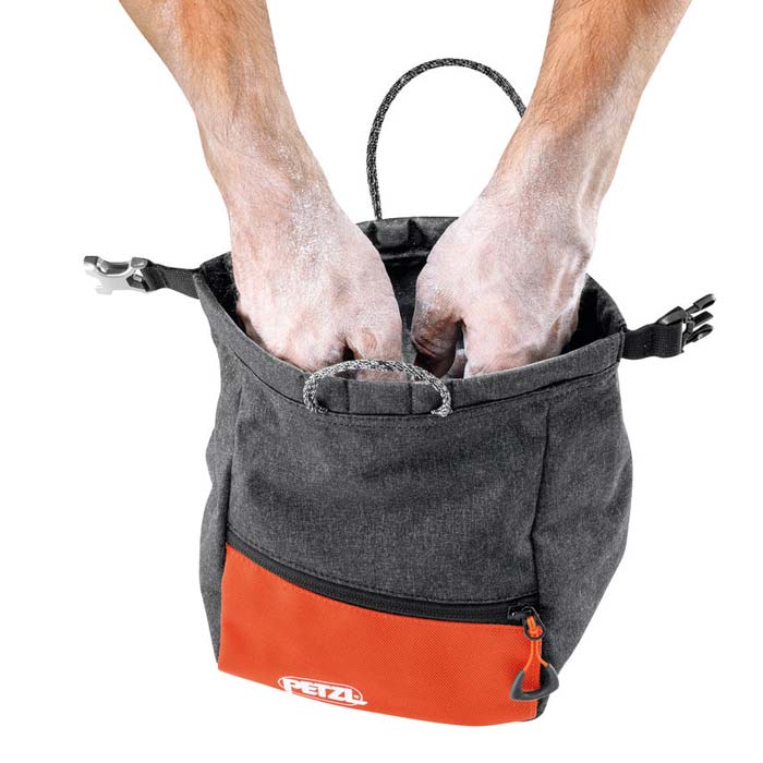 Das Bild zeigt zwei Kletterer Hände im Petzl Sakab Boulder Chalkbag von seitlich oben.