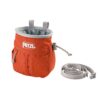 Das Bild zeigt das orange Petzl Sakapoche Chalkbag mit Tasche von der Seite. MAn erkennt Form, Logo, Kordelzug und den nebenliegenden Gürtel.