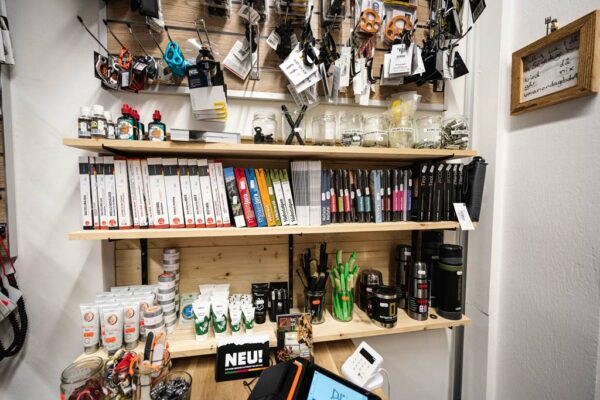 Kletterführer, Boulderführer und Kletterzubehör auf einer Verkaufswand im bolting.eu Bergsportshop Innsbruck.